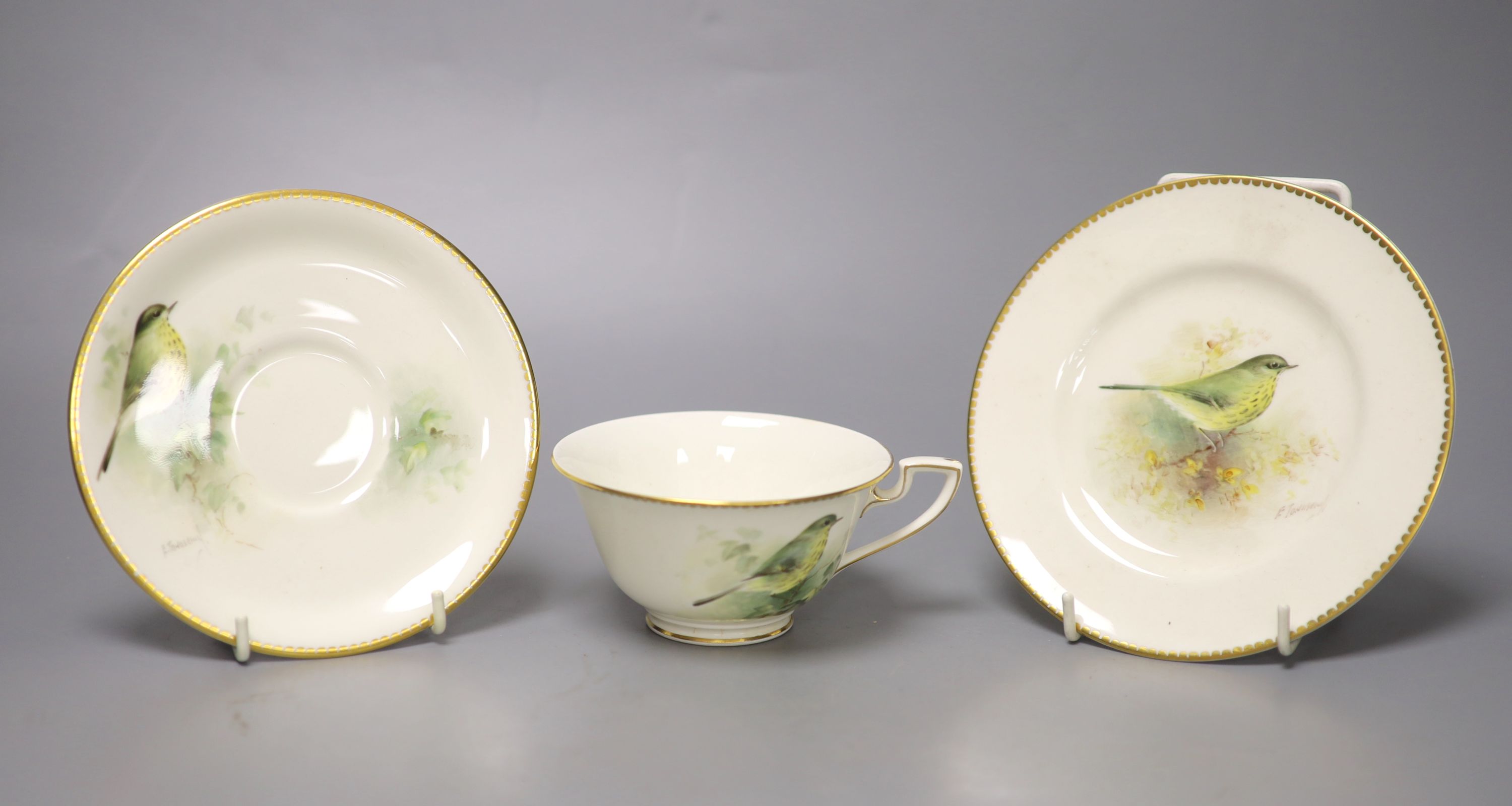 A Royal Worcester teacup, saucer and side plate, each unusually painted with a thrush on a branch by E. Townsend, signed black mark,